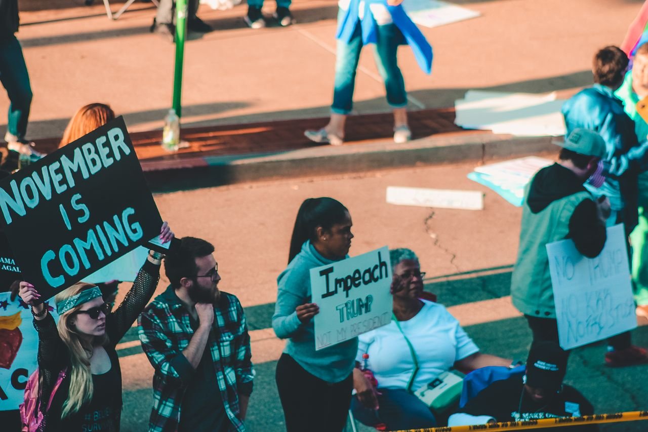 Group of people at a street protest holding political signs in Wheeling, WV.